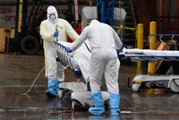 Nhân viên y tế Mỹ đưa thi thể bệnh nhân ra xe đông lạnh tại New York hôm 9/4. Ảnh: AFP.