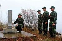 Các chiến sĩ biên phòng đứng trước cột mốc thiêng liêng của Tổ quốc trong một buổi tuần tra giáp Tết
