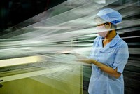 Công nhân kiểm tra chất lượng sợi trên dây chuyền sản xuất.