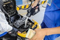 Nhân viên cây xăng ở góc đường Lê Thánh Tôn (TP HCM) bơm xăng cho khách hàng. Ảnh: Nguyễn Thành.