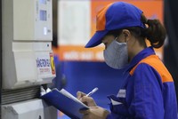 Nhân viên của một cây xăng thuộc hệ thống Petrolimex thống kê sản lượng bán hàng. Ảnh: Ngọc Thành.