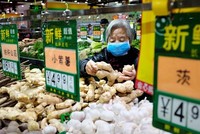 Một phụ nữ chọn gừng trong siêu thị ở Bắc Kinh hồi tháng 4. Ảnh: Reuters.