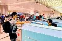 Làm thủ tục nhập cảnh tại cửa khẩu Tân Sơn Nhất. (Ảnh: Thành Chung/TTXVN).
