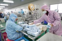 Công nhân nỗ lực may khẩu trang y tế tại một nhà máy ở Vũ Hán, Trung Quốc. (Ảnh: THX/TTXVN).