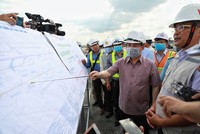 Bộ trưởng Giao thông Vận tải Nguyễn Văn Thể chỉ vào bản đồ sân bay và vị trí thi công tại dự án cải tạo đường băng 25R/07L Tân Sơn Nhất, chiều 29/8.