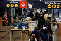 Du khách làm thủ tục tại Sân bay Quốc tế Seattle-Tacoma ở SeaTac, Washington, Mỹ ngày 12/4. (Nguồn: Reuters).