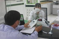 Khách hàng giao dịch tại Ngân hàng TMCP Ngoại thương Việt Nam chi nhánh tỉnh Kon Tum. (Ảnh minh họa: Dư Toán/TTXVN).