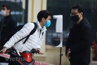 Học sinh được đo thân nhiệt và khử khuẩn tại khu vực cổng trường trước khi lên lớp. (Ảnh: Hoài Nam/Vietnam+).