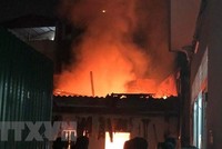 Hiện trường đám cháy lớn bùng phát khiến người dân xung quanh hoảng sợ. (Ảnh: TTXVN phát).