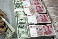 Nhân viên kiểm đồng USD (trái) và đồng nhân dân tệ tại một ngân hàng ở tỉnh An Huy, Trung Quốc. (Ảnh: AFP/TTXVN).