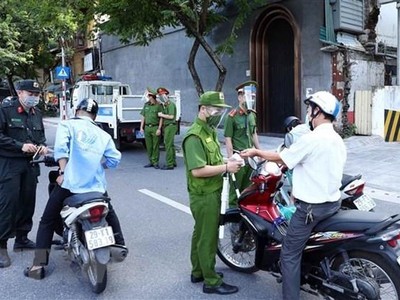 Lực lượng Công an Hà Nội kiểm tra giấy tờ của người tham gia giao thông tại chốt liên ngành tuyến phố Trần Quang Khải (quận Hoàn Kiếm). (Ảnh: Phạm Kiên/TTXVN).
