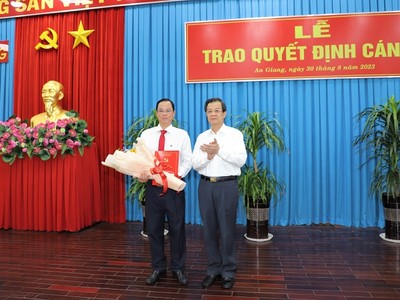 Bí thư Tỉnh ủy An Giang Lê Hồng Quang trao Quyết định và tặng hoa chúc mừng ông Thái Minh Hiển. Ảnh: angiang.gov.vn