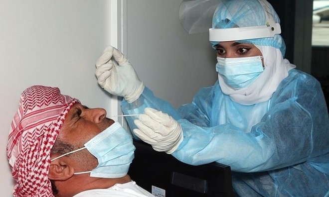 Nhân viên y tế lấy mẫu xét nghiệm nCoV tại sân bay quốc tế Muscat ở thủ đô Oman. Ảnh: AFP.