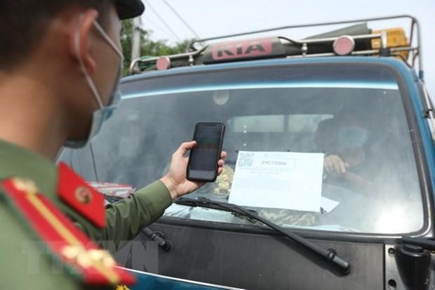 Lực lượng chức năng tại chốt kiểm soát đầu cầu Trung Hà (huyện Ba Vì) quét mã QR Code kiểm tra thông tin phương tiện theo đăng ký khi qua chốt. (Ảnh: Minh Quyết/TTXVN).