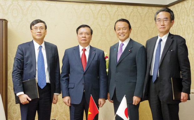 Bộ trưởng Đinh Tiến Dũng (thứ hai từ trái sang), Chủ tịch UBCK Vũ Bằng (ngoài cùng bên trái) chụp hình với Bộ trưởng Tài chính Nhật Bản Taro Aso (thứ 3 từ trái sang) trong chuyến công tác của Bộ trưởng tháng 3/2014.  