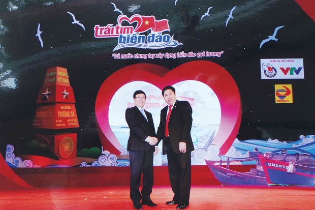 Phó thủ tướng Chính phủ Phạm Bình Minh chúc mừng doanh nhân Bùi Tùng Mậu trong Chương trình giao lưu “Trái tim biển đảo” tại Nhà hát lớn Hà Nội (10/3/2014)