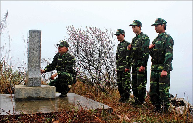 Các chiến sĩ biên phòng đứng trước cột mốc thiêng liêng của Tổ quốc trong một buổi tuần tra giáp Tết 