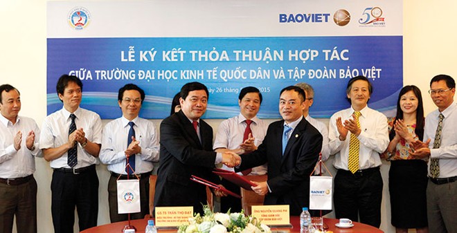 Ông Nguyễn Quang Phi (bên phải), Tổng giám đốc Tập đoàn Bảo Việt ký kết thỏa thuận hợp tác  và trao tặng học bổng trị giá 5 tỷ đồng cho sinh viên nghèo vượt khó tại Trường ĐH Kinh tế Quốc dân