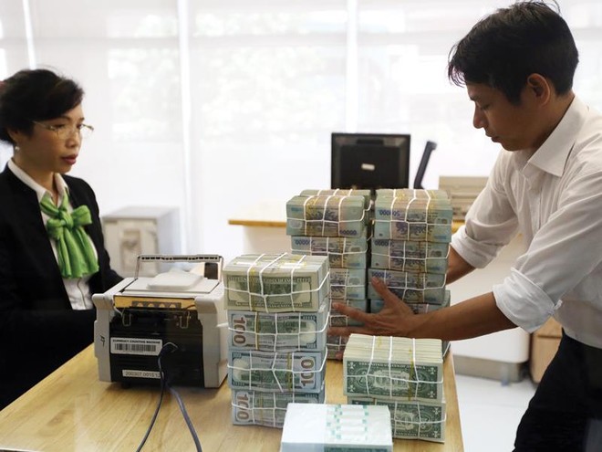 Tỷ giá USD đang chịu nhiều áp lực từ bên ngoài . Trong ảnh: giao dịch tại Ngân hàng Vietcombank. Ảnh: Đ.T