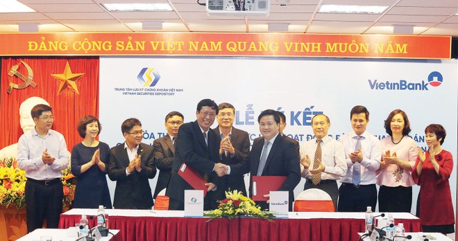 Ông Dương Văn Thanh, Tổng giám đốc VSD (bên trái) và ông Lê Đức Thọ, Tổng giám đốc VietinBank (bên phải) trao đổi biên bản ký thỏa thuậ hợp tác 