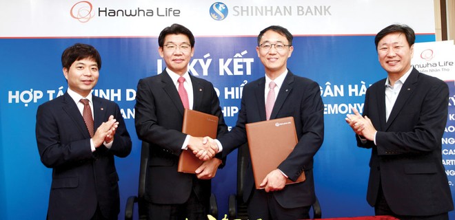 Ông Back Jong Kook (thứ hai từ trái sang) bắt tay đại diện của Ngân hàng Shinhan bank tại buổi lễ ký kết hợp tác chiến lược ngày 12/6/2017