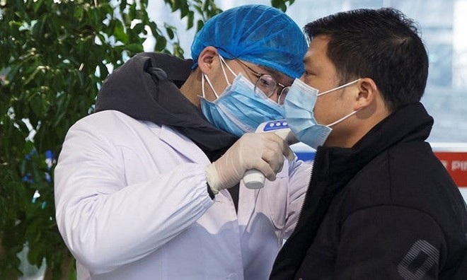 Nhân viên y tế kiểm tra sức khỏe  ở sân bay Trường Sa, tỉnh Hồ Nam, hôm 27/1. Ảnh: Reuters.