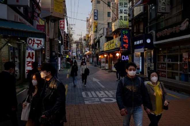Người dân đi bộ trên đường phố Seoul hôm 24/3. Ảnh: AFP