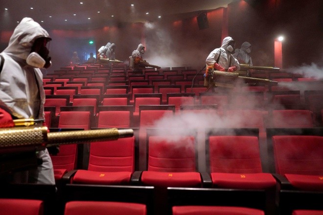 Đội tình nguyện phun khử trùng tại rạp chiếu phim Qintai Grand ở Vũ Hán hôm 2/4. Ảnh: Reuters.