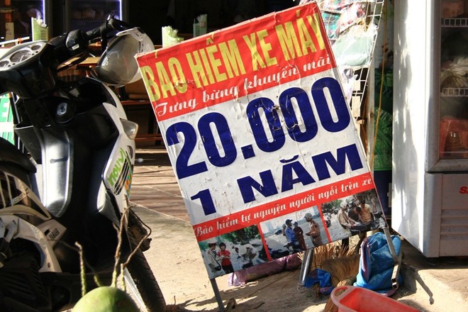 Những biển quảng cáo bán bảo hiểm xe máy với giá 20.000 đồng/năm xuất hiện nhan nhản trên các tuyến phố ở Hà Nội