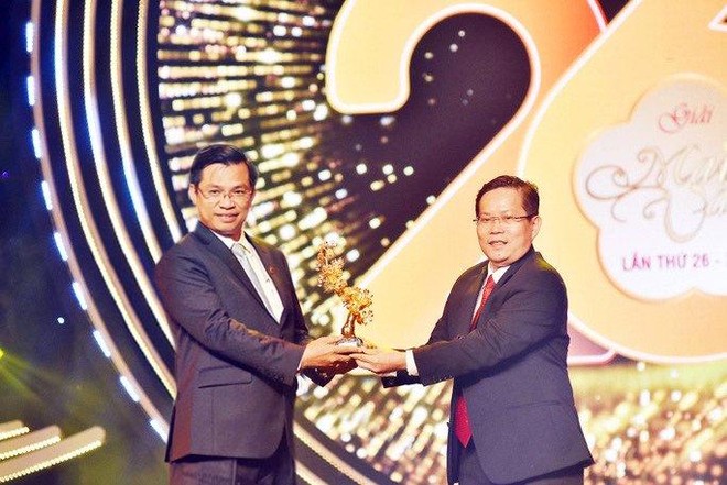 Ông Trần Ngọc Tâm - Tổng giám đốc Nam A Bank (bìa trái) tiếp nhận “Nhành Mai Vàng” từ Tổng biên tập Báo Người lao động - ông Tô Đình Tuân.