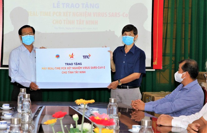 Đại diện Công ty cổ phần Khu công nghiệp Thành Thành Công (áo xanh nhạt) trao biểu trưng tặng máy xét nghiệm Real-time PCR cho lãnh đạo Sở Y tế Tây Ninh