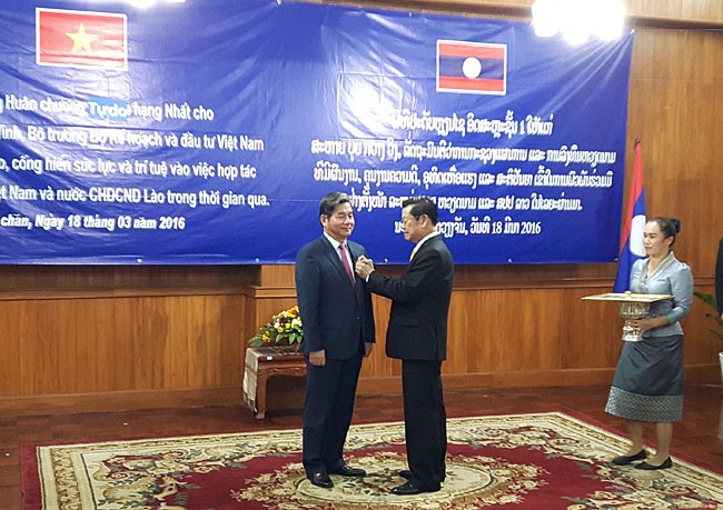 Thừa ủy quyền của Chủ tịch nước CHDCND Lào, Phó Thủ tướng Chính phủ Lào Xomxavat Lengxavath trao tặng cho Bộ trưởng Bùi Quang Vinh Huân chương Isala hạng Nhất
