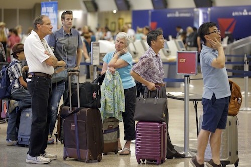 Hành khách của Delta Air Lines xếp hàng chờ làm thủ tục sau khi nhiều chuyến bay bị trễ do hệ thống mạng bị tấn công. Ảnh: AP.
