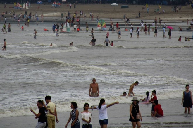 Hàng nghìn du khách tắm biển, bất chấp cảnh báo bão
