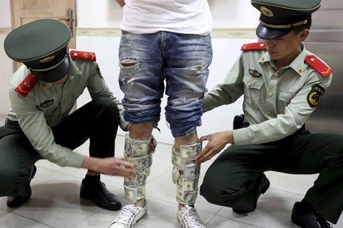Một người bị bắt vì chuyển tiền lậu từ Trung Quốc sang Hong Kong. Ảnh: Reuters