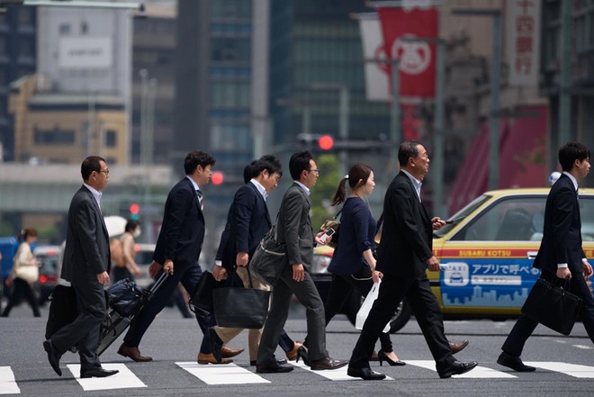 Nhân viên công sở đi bộ đến nơi làm việc ở Tokyo. Ảnh: Japan Times. 