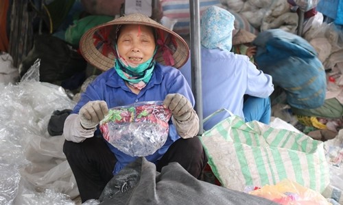 Bà Nguyễn Thị Hồng Thắm cầm một vỏ túi kẹo có xuất xứ từ Mỹ. Ảnh: Guardian.