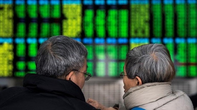 Trái với nhiều thị trường khác, chứng khoán Trung Quốc biểu thị màu xanh là giảm điểm, màu đỏ là tăng điểm. Ảnh: AFP