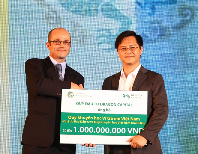 Ông Nguyễn Hồng (phải), Phó Tổng biên tập Báo Đầu Tư đón nhận tiền tượng trưng cho quỹ học bổng của báo từ đại diện của Dragon Capital - ảnh: Lê Toàn