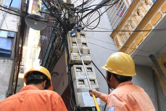 Công nhân đo chỉ số công-tơ điện của người dân trên phố Thái Hà
