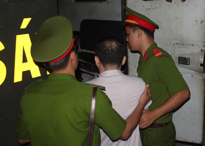 Ông Lương Văn Thảo được công an hỗ trợ tư pháp đưa ra xe sau phiên tòa. Ảnh: H.X.