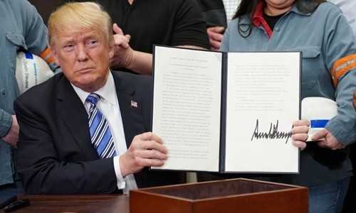 Tổng thống Donald Trump ký lệnh áp thuế nhập khẩu nhôm, thép tại Nhà Trắng ngày 8/3. Ảnh: AFP.