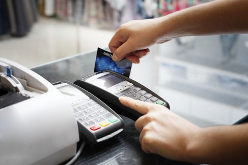 Thanh toán thẻ ngân hàng qua máy POS tại một điểm mua hàng. 