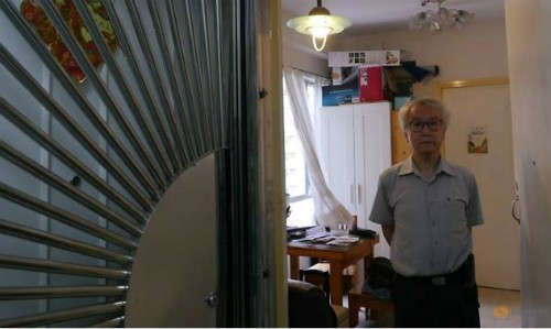 Ông chủ nhà Ng Goon-lau, 66 tuổi, đứng trong căn hộ của mình, nơi từng xảy ra hai vụ tự tử, một người đàn ông tự tử bằng than, một nữ cảnh sát treo cổ. Ảnh: Reuters.