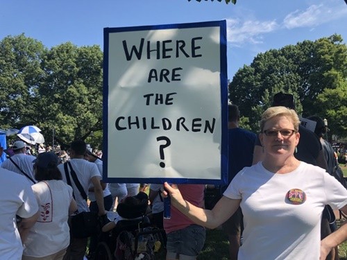 Một phụ nữ tham gia cuộc biểu tình ngày 30/6 ở Washington giơ cao tấm biển với dòng chữ ghi "Những đứa trẻ ở đâu?". Ảnh: CNN.