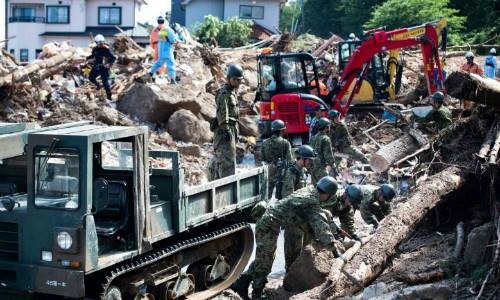Lực lượng cứu hộ và binh sĩ dọn dẹp đống đổ nát trên một con phố sau trận lụt ở Kumano, tỉnh Hiroshima, ngày 9/7. Ảnh: AFP.