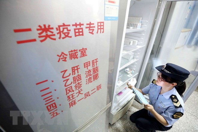 Nhân viên thực thi pháp luật thuộc Cơ quan quản lý và giám sát thị trường kiểm tra việc cung ứng vắc-xin tại Dung An, khu tự trị dân tộc Choang Quảng Tây, Trung Quốc ngày 23/7 vừa qua. (Ảnh: EPA/TTXVN).