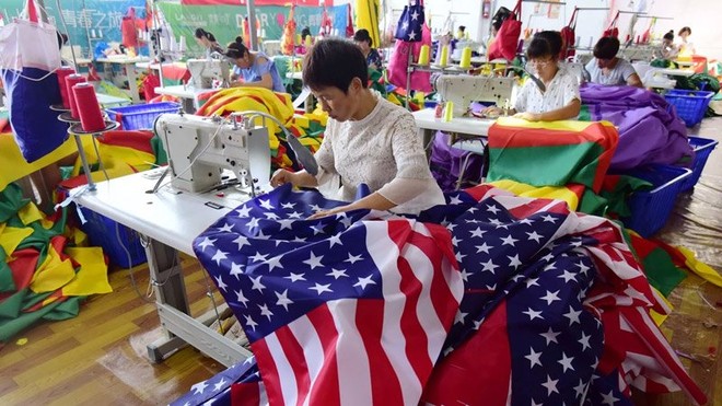Công nhân Trung Quốc đang may cờ Mỹ tại một nhà máy ở Fuyang thuộc tỉnh An Huy, miền đông Trung Quốc. Ảnh: SCMP.