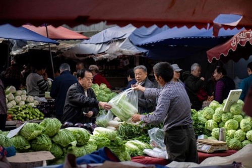 Người dân mua đồ tại một khu chợ ở Bắc Kinh (Trung Quốc). Ảnh: AFP.