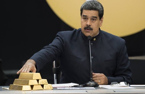 Tổng thống Maduro chạm vào các thỏi vàng trong cuộc họp với các bộ trưởng phụ trách lĩnh vực kinh tế ở Caracas tháng 3/2018. Ảnh: Reuters.